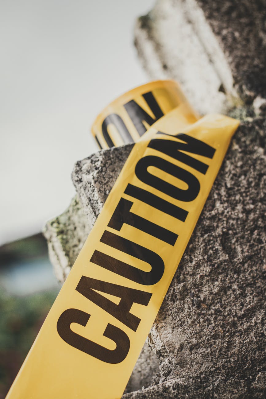inscription caution on yellow tape on stone