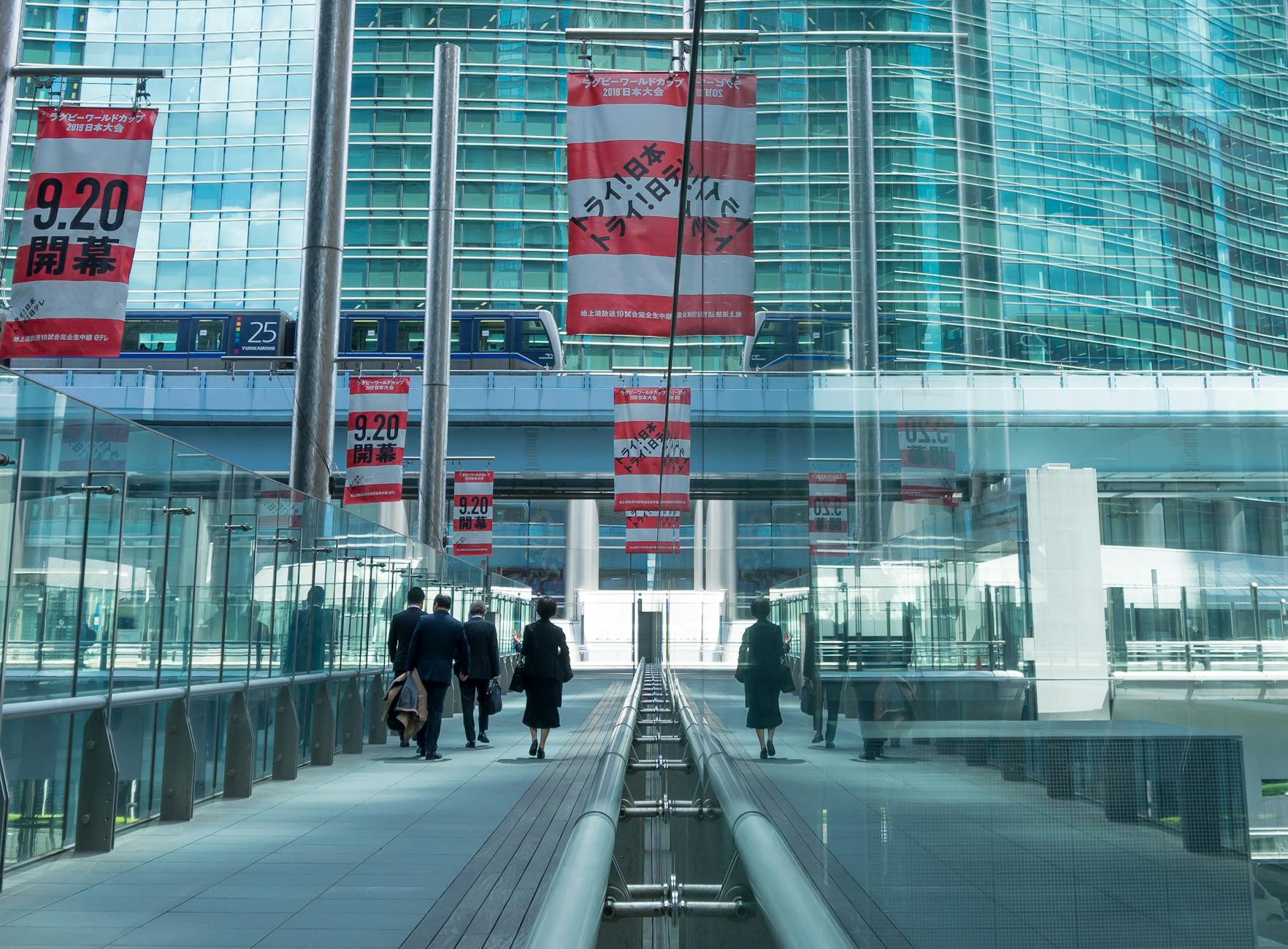 urban commuters on modern glass bridge