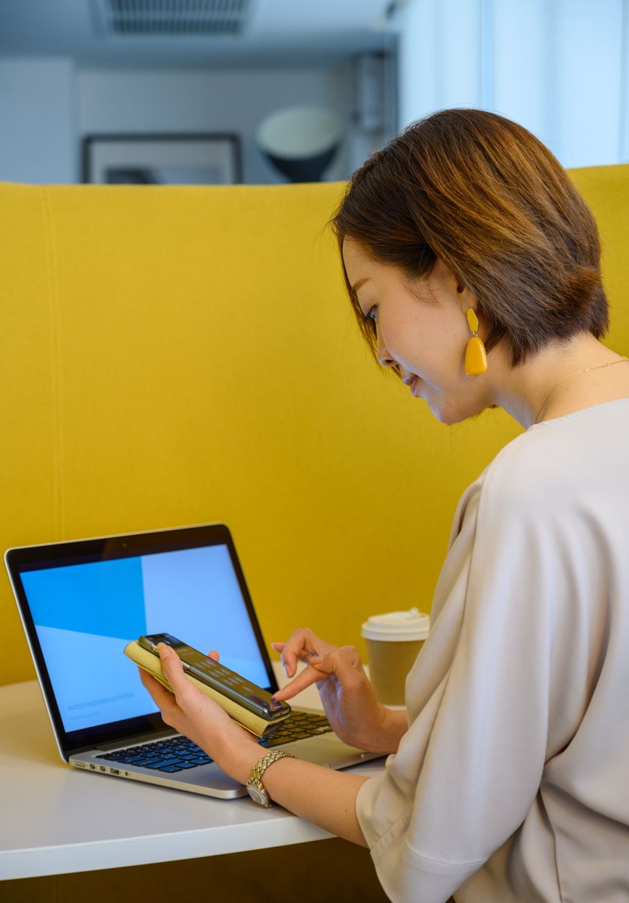 woman sitting while using her smartphone
