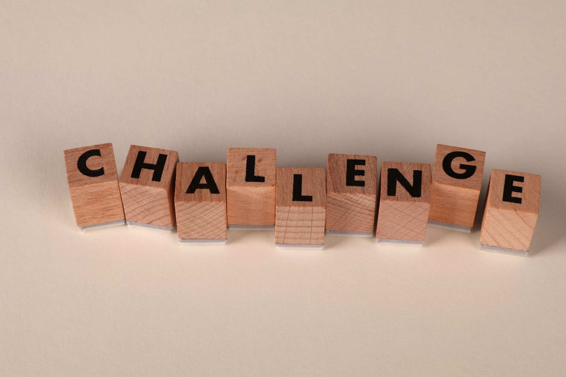 wooden blocks spelling challenge on neutral background